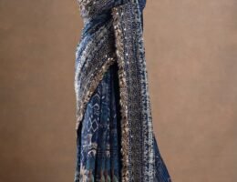 The deep blue base is beautifully enhanced with intricate printed motifs, ornate borders and rich metallic embellishments.