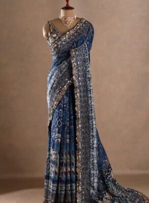 The deep blue base is beautifully enhanced with intricate printed motifs, ornate borders and rich metallic embellishments.