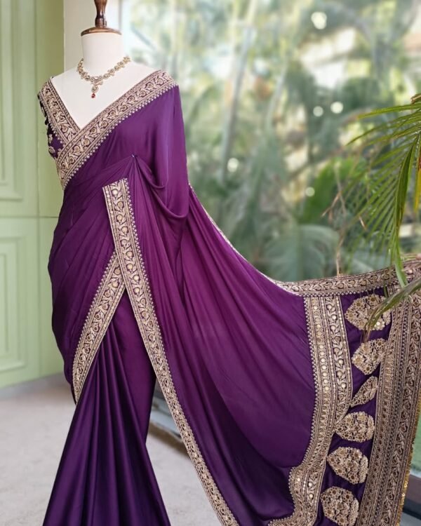 Purple party wear saree with ornate gold-tone border and decorative pallu