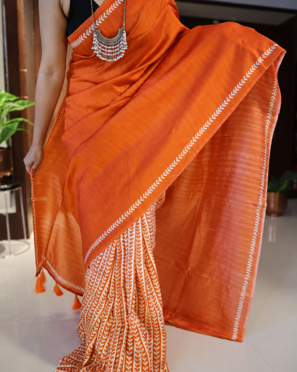 Orange handpainted Tussar silk saree with cream leaf motifs and tasselled pallu